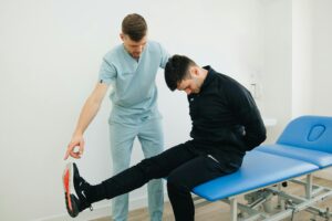 physical therapist helping a patient stretch his leg